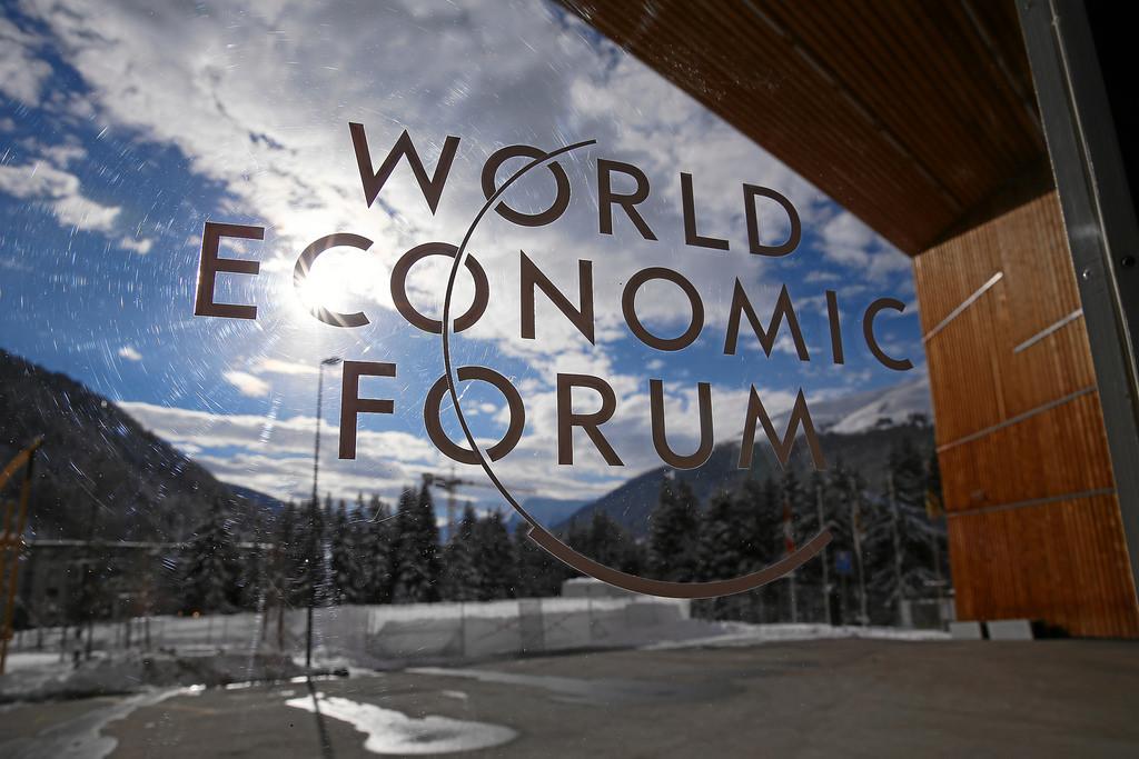 Image of a panel discussion at the World Economic Forum, with global leaders in business and politics discussing economic issues.
