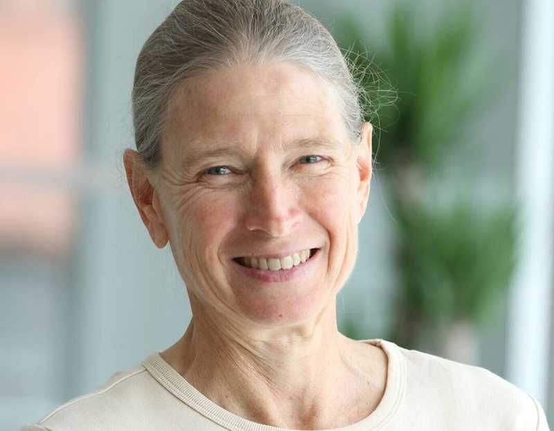 Portrait of a smiling woman with gray hair looking directly at the camera.