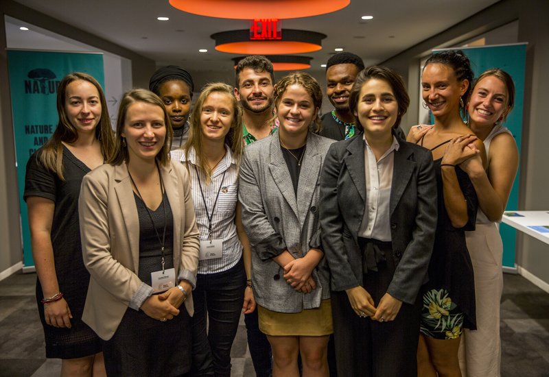 A group of young people smiling and posing for a photo inside a department building.