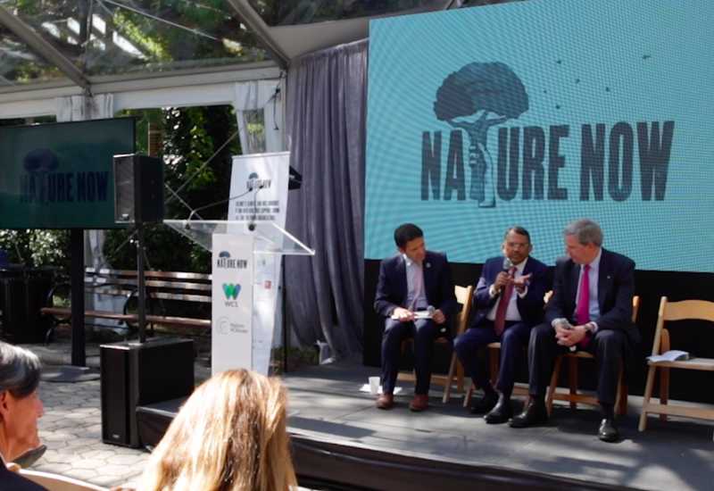 Four people sitting on stage at a nature show event.