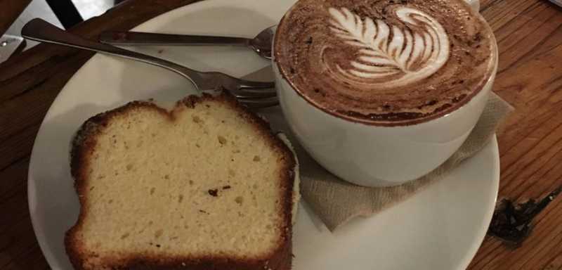 A slice of bread and a cup of coffee on a plate.