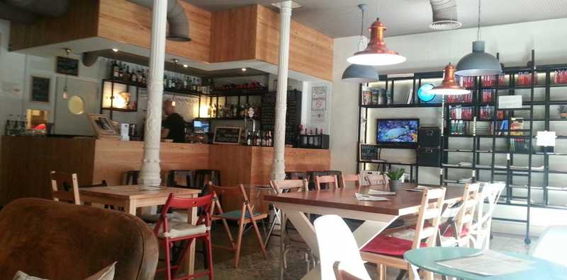 A cozy restaurant featuring tables and chairs arranged in front of an extensive bookcase filled with books.