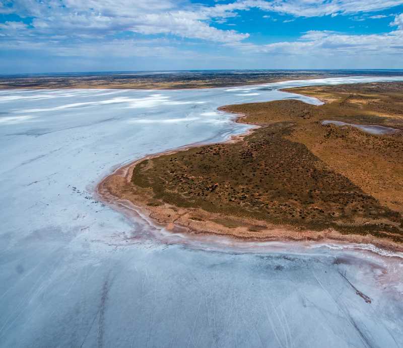 Aerial perspective of a salt lake surrounded by desert, illustrating the impact of climate change on natural landscapes.