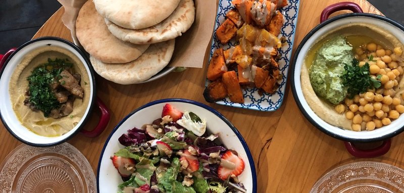 A table set with bowls of food and pita bread, ready for a delicious meal.