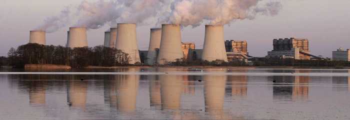 large power plant with multiple chimneys emitting smoke into the sky, showcasing industrial activity and energy production.