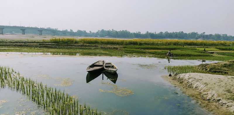 solitary boat navigates through the tranquil waters of a river, framed by vibrant trees and a peaceful landscape.