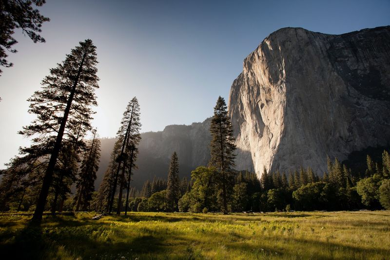 The sun shines on Half Dome mountain in Yosemite National Park, highlighting its majestic peak.